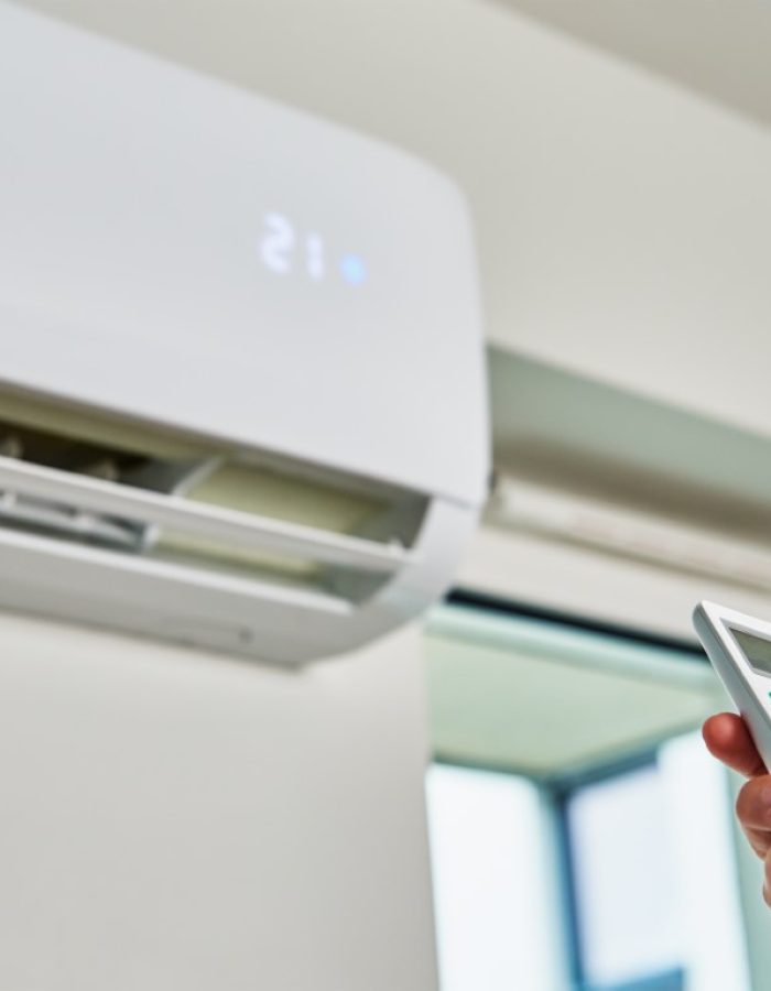 hand-adjusting-temperature-on-air-conditioner-2022-12-16-12-44-47-utc (Közepes)